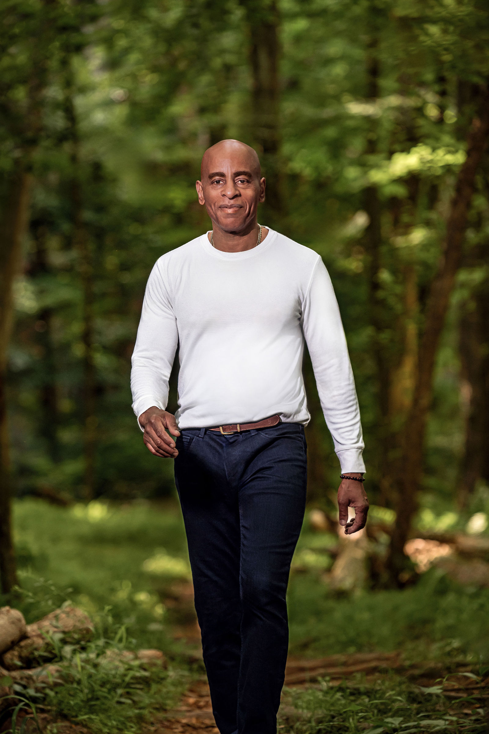 Terry Henry, founder of Dialed In Dating, walking through a sunlit forest path
